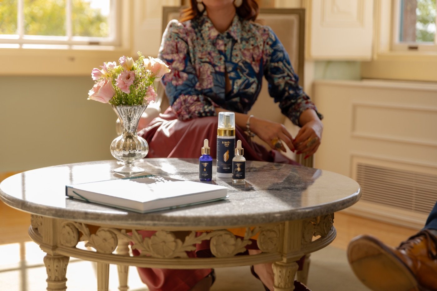 Carolina Antony com produtos Lumière D'Or num ambiente do palácio